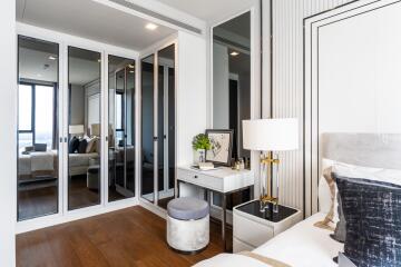 Modern and stylish bedroom with mirrored closets and a small desk