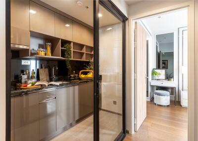 Modern kitchen with glass sliding door and view into hallway