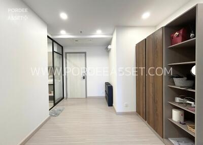 Modern hallway with wooden shelving and glass door to a room