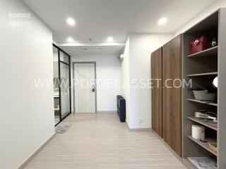 Modern hallway with wooden shelving and glass door to a room