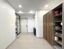 Modern hallway with wooden shelving and glass door to a room