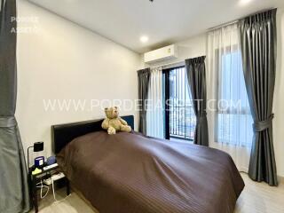 Bedroom with a bed, two side tables, an air conditioner, and a window