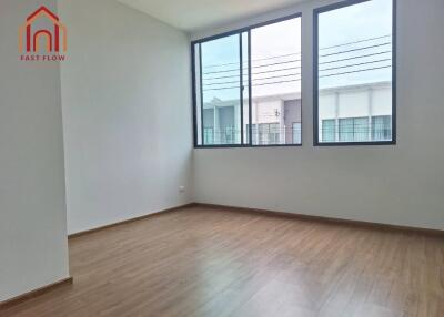 Bright empty bedroom with large windows and wooden flooring