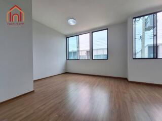 Spacious living room with large windows and wooden flooring