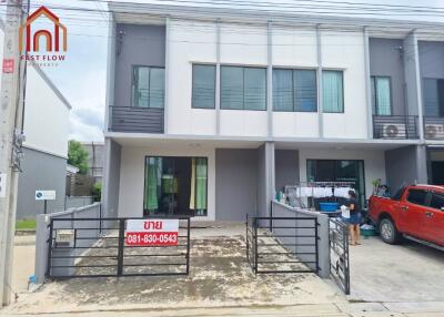 Exterior view of a modern townhouse with driveway and front yard