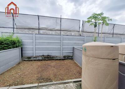 Enclosed backyard with water tanks and potted plant