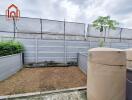 Enclosed backyard with water tanks and potted plant