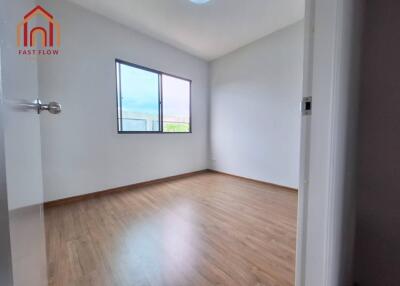 Spacious bedroom with wooden flooring and large window