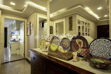 Decorated hallway with mirror and view into kitchen