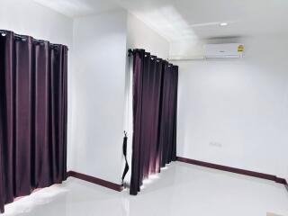 Modern bedroom with black curtains and a split air conditioning unit