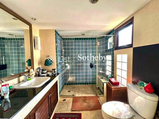 Spacious bathroom with modern amenities and blue-tiled shower area