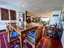 Spacious dining area with a wooden table and chairs, colorful décor, and a well-lit open layout