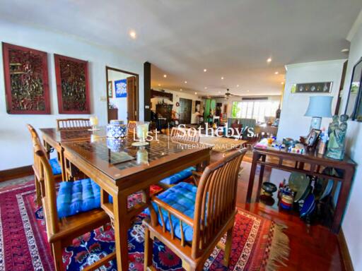 Spacious dining area with a wooden table and chairs, colorful décor, and a well-lit open layout