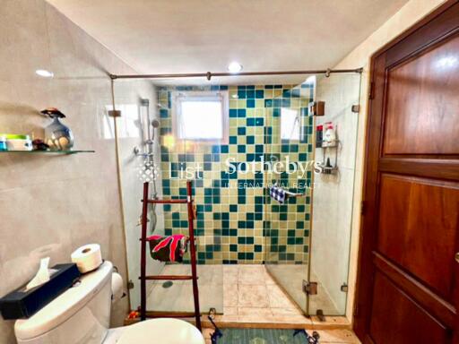 Modern bathroom with glass shower enclosure and mosaic tile design