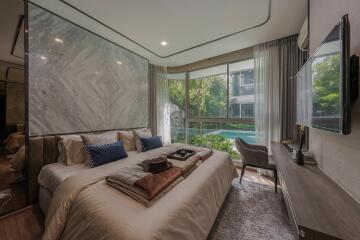 Modern bedroom with large windows and a view of a pool.