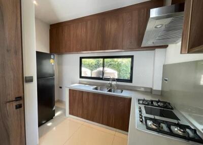 Modern kitchen with wooden cabinets and black refrigerator