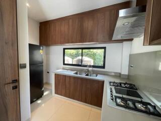 Modern kitchen with wooden cabinets and black refrigerator