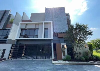 Modern exterior of a multi-story residential building with large windows and gated entrance