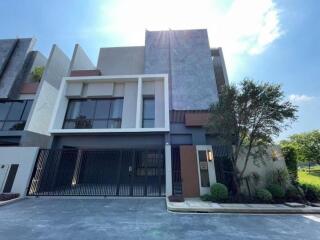 Modern exterior of a multi-story residential building with large windows and gated entrance