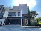 Modern facade of a multi-story residential building with a gated entrance