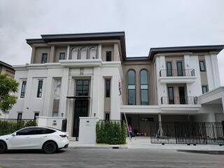 Modern luxury townhouse exterior with cars parked in front