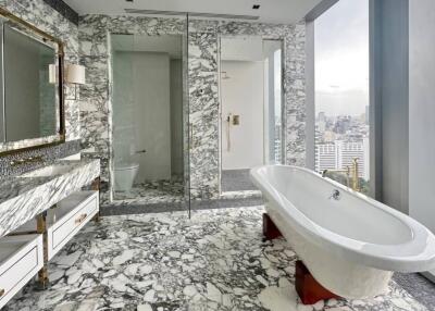 Modern luxurious bathroom with marble flooring and freestanding bathtub