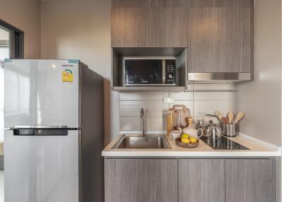 Modern compact kitchen with refrigerator and microwave