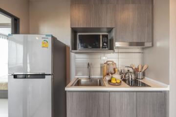 Modern compact kitchen with refrigerator and microwave