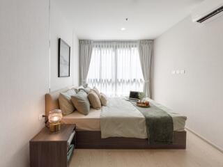 Modern bedroom with large window, bed, and decor