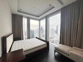 Modern bedroom with floor-to-ceiling windows offering a city view