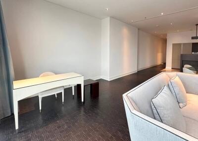 Modern living area with a sofa, desk, and dark wooden flooring