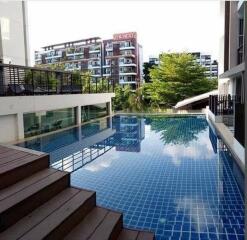 Modern outdoor swimming pool with wooden deck in a residential area