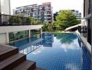 Modern outdoor swimming pool with wooden deck in a residential area