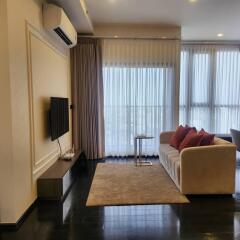 Modern living room with sofa, TV, air conditioner, and full-length curtains