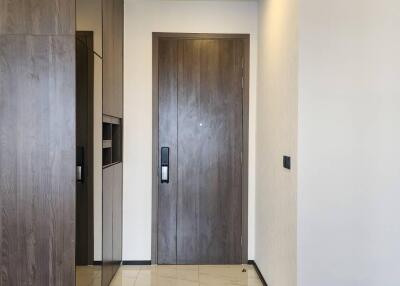 Modern apartment entrance with wooden door and tiled floor