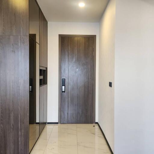 Modern apartment entrance with wooden door and tiled floor