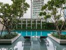 Outdoor swimming pool with lounge chairs and greenery