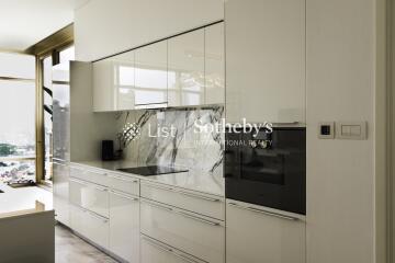 Modern kitchen with sleek white cabinetry and marble backsplash