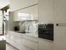 Modern kitchen with sleek white cabinetry and marble backsplash