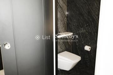 Modern bathroom with black marble walls and white fixtures