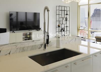 Modern kitchen with sink, counter, and view of living area