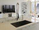 Modern kitchen with sink, counter, and view of living area