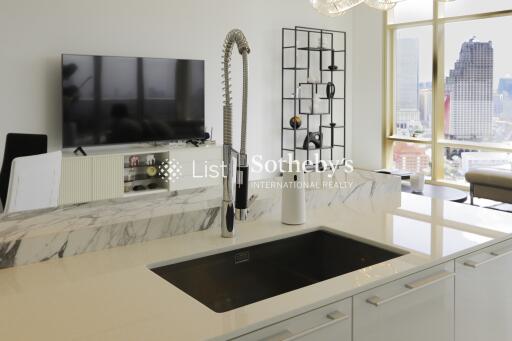 Modern kitchen with sink, counter, and view of living area