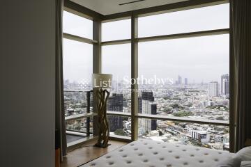 Bedroom with large windows overlooking the city