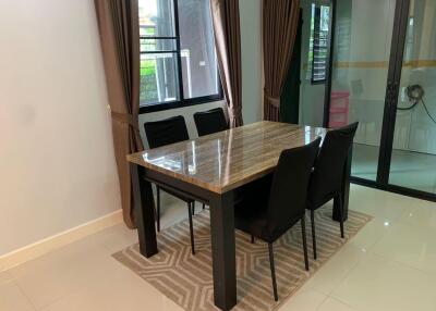 Dining area with a marble table and black chairs