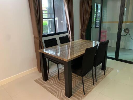 Dining area with a marble table and black chairs