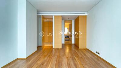 Spacious modern bedroom with wooden flooring and built-in storage