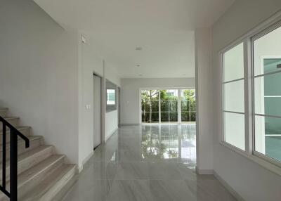 Spacious main living space with large windows and staircase