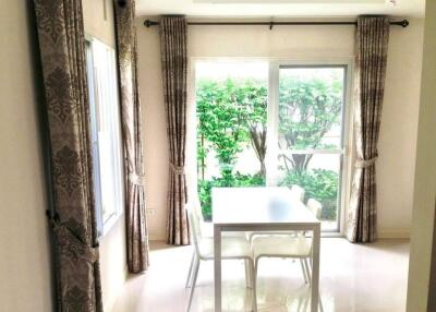 Bright dining area with large windows and view of greenery