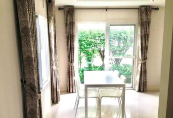 Bright dining area with large windows and view of greenery